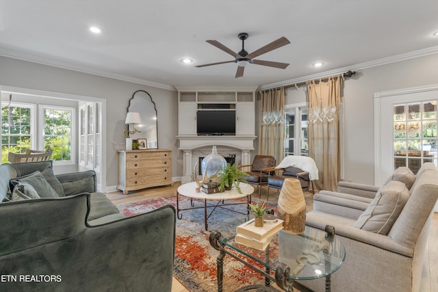 living room with light wood-type flooring, ceiling fan, and crown molding