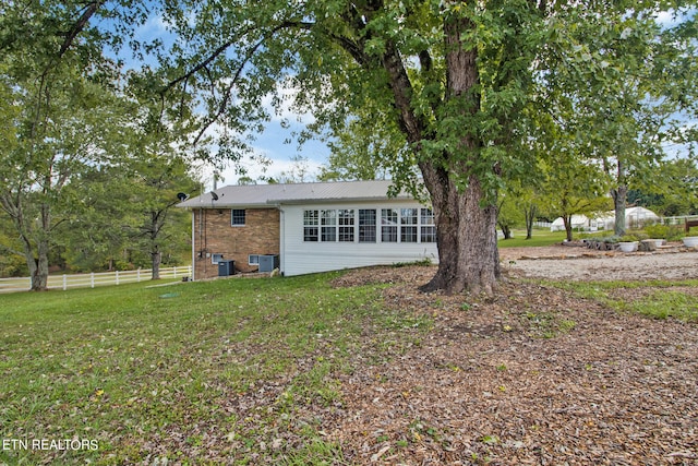 view of front facade with central AC and a front yard