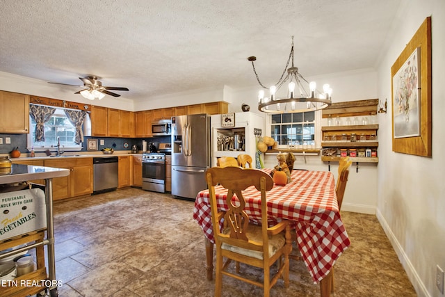 dining area featuring a textured ceiling, ceiling fan with notable chandelier, crown molding, and sink