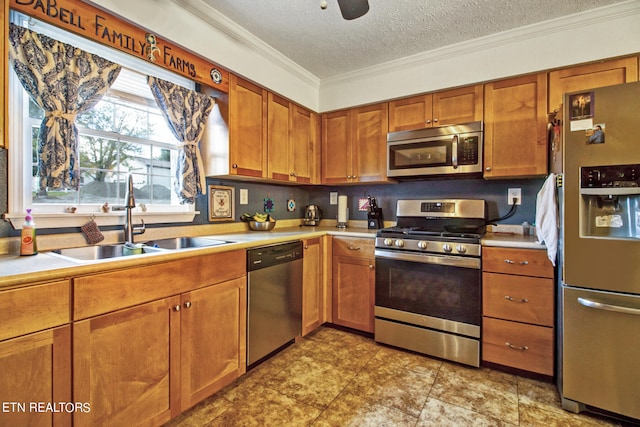 kitchen with appliances with stainless steel finishes, a textured ceiling, ornamental molding, and sink