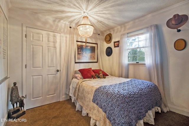 carpeted bedroom featuring a chandelier, a textured ceiling, and crown molding