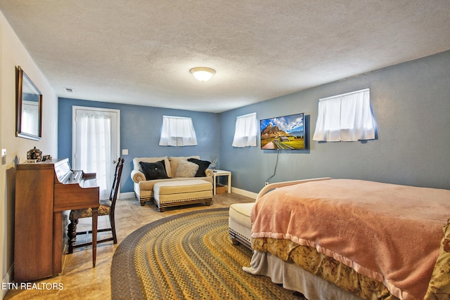 bedroom featuring a textured ceiling and light colored carpet