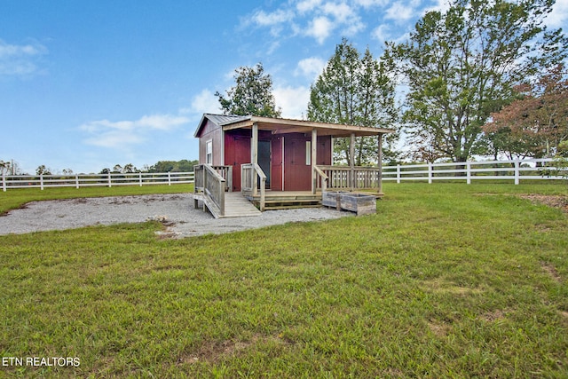 view of outdoor structure with a rural view and a yard