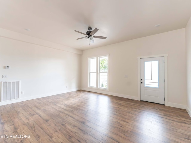 empty room with ceiling fan and hardwood / wood-style flooring