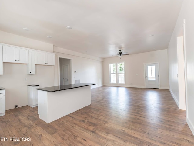 kitchen with light hardwood / wood-style floors, a center island, ceiling fan, and white cabinets