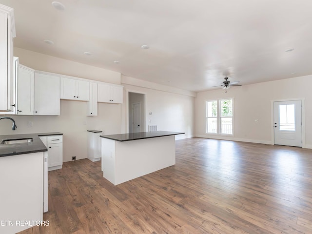 kitchen with white cabinetry, a kitchen island, and sink