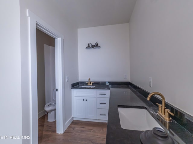 bathroom featuring wood-type flooring, vanity, and toilet