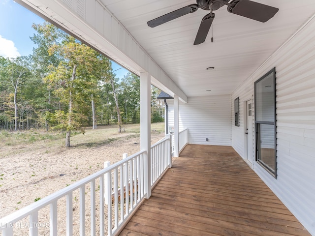 wooden terrace with ceiling fan and covered porch