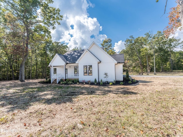 modern farmhouse with a front lawn and a porch