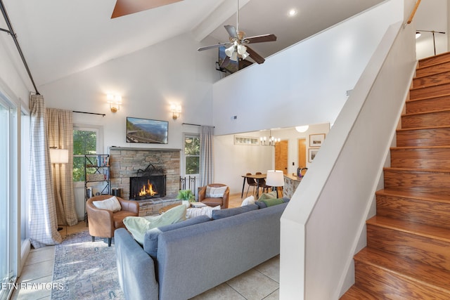 living room featuring beam ceiling, ceiling fan, high vaulted ceiling, light tile patterned flooring, and a stone fireplace