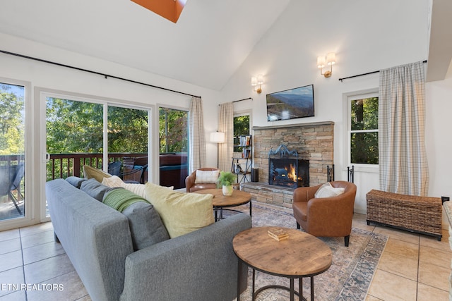 living room with a wealth of natural light, a fireplace, high vaulted ceiling, and light tile patterned floors