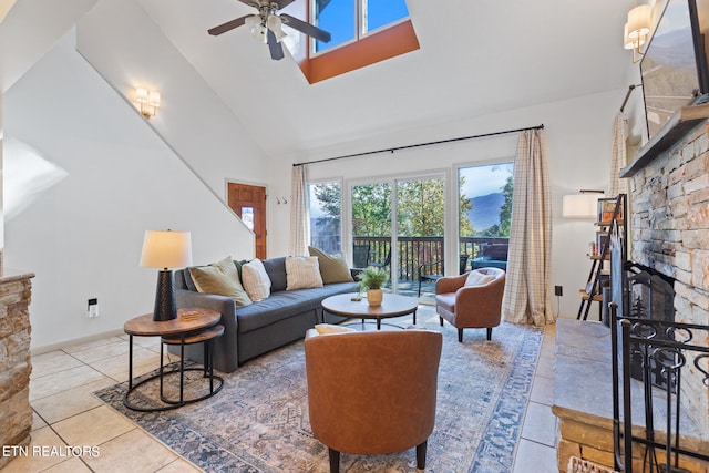 tiled living room featuring high vaulted ceiling, a fireplace, and ceiling fan