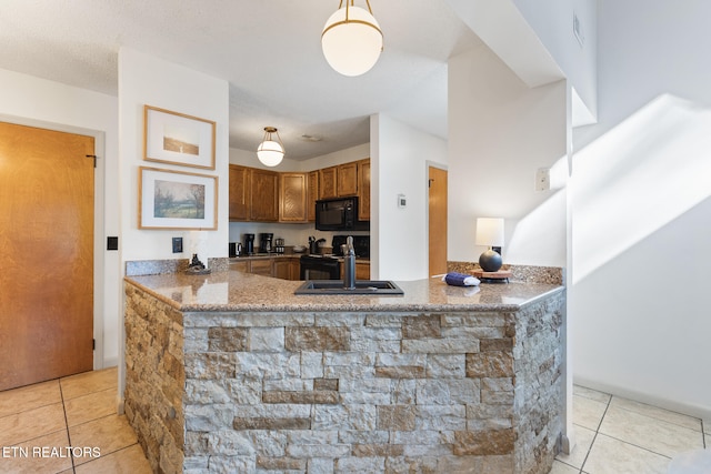 kitchen with black appliances, sink, kitchen peninsula, pendant lighting, and light tile patterned floors