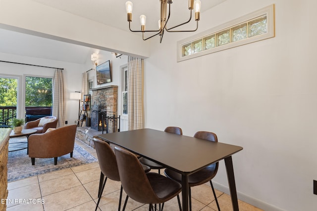 tiled dining space featuring a stone fireplace