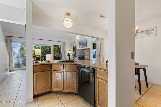 kitchen featuring black dishwasher, sink, a fireplace, a textured ceiling, and light tile patterned floors