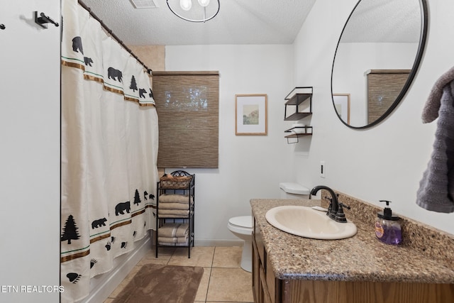 bathroom with a textured ceiling, toilet, vanity, curtained shower, and tile patterned flooring