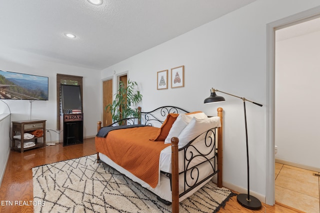 bedroom featuring hardwood / wood-style flooring and a textured ceiling