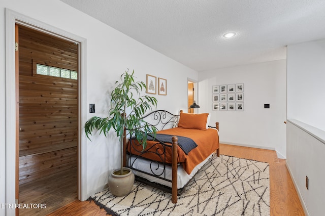 bedroom with hardwood / wood-style floors and a textured ceiling