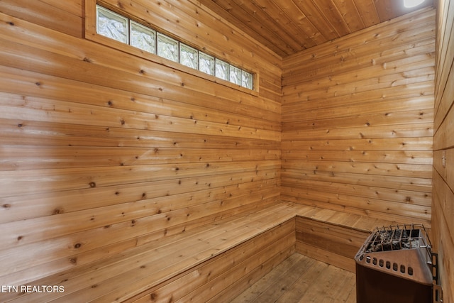 view of sauna featuring hardwood / wood-style floors, a healthy amount of sunlight, wooden walls, and wooden ceiling