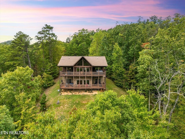 back house at dusk with a deck