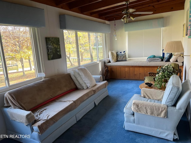 sunroom / solarium with ceiling fan, plenty of natural light, and beamed ceiling