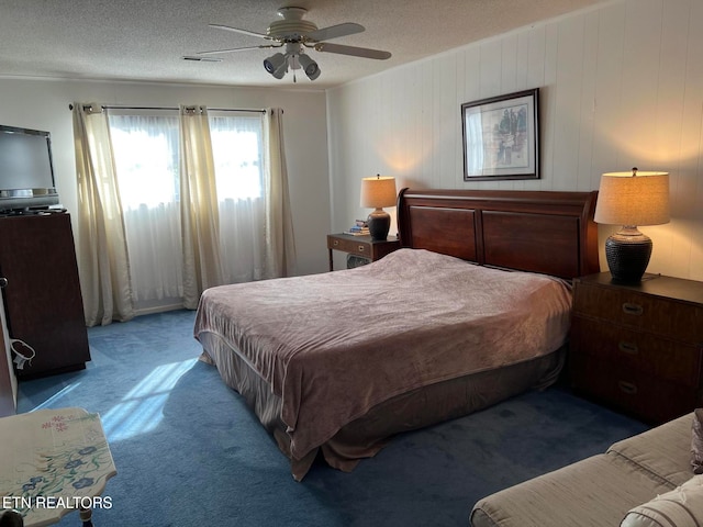 bedroom with dark colored carpet, a textured ceiling, ceiling fan, and wood walls