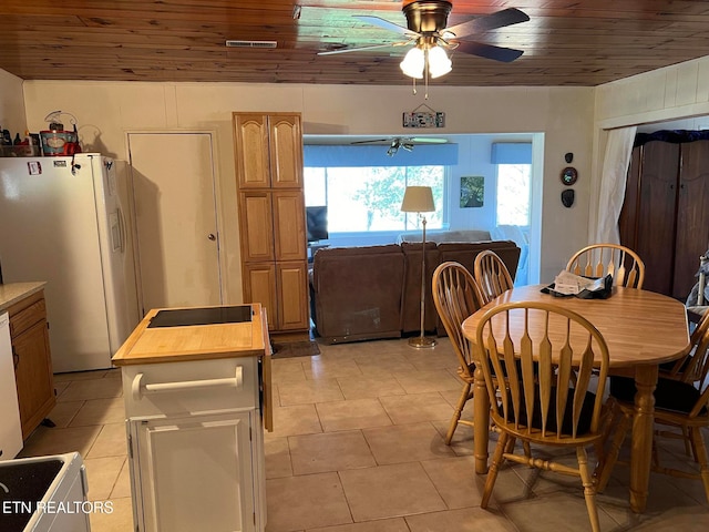 tiled dining space with ceiling fan and wooden ceiling