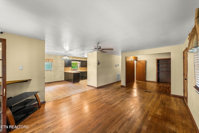 unfurnished living room featuring ceiling fan and hardwood / wood-style flooring