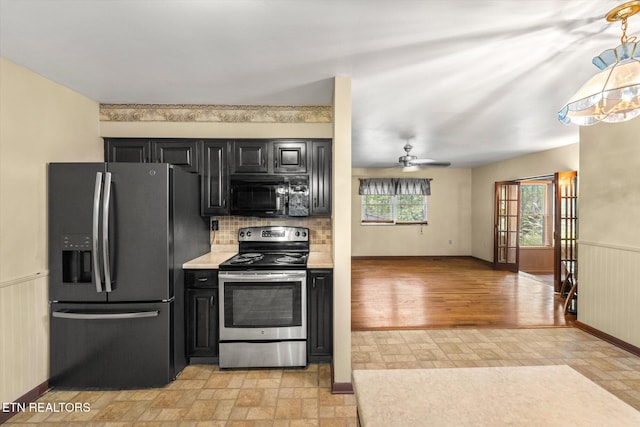 kitchen with backsplash, stainless steel appliances, ceiling fan, light hardwood / wood-style flooring, and wooden walls