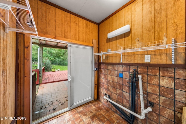 doorway to outside with wooden walls