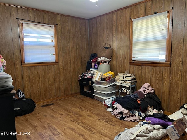 bedroom with light hardwood / wood-style flooring and wood walls