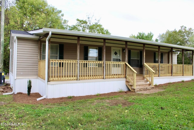 view of front of property with central AC unit, a front yard, and covered porch