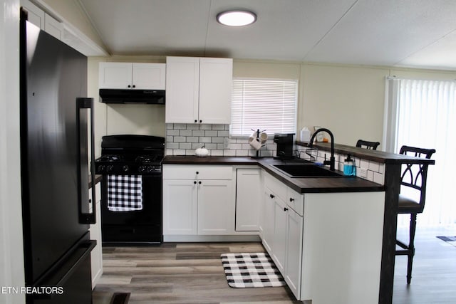 kitchen featuring sink, white cabinetry, a healthy amount of sunlight, and black appliances