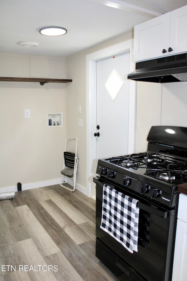 kitchen with black gas range oven, light hardwood / wood-style flooring, and white cabinetry