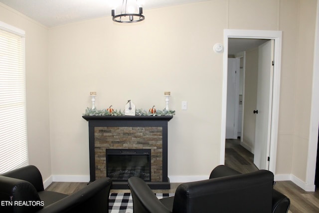 living room featuring wood-type flooring, a fireplace, and ornamental molding