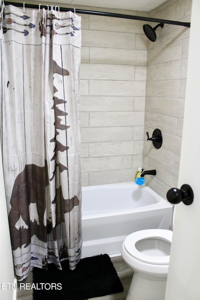 bathroom featuring shower / bath combination with curtain and toilet