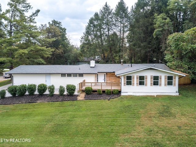 rear view of property with a deck and a lawn