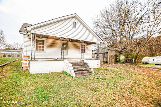 bungalow-style home featuring a storage shed, a front lawn, and covered porch