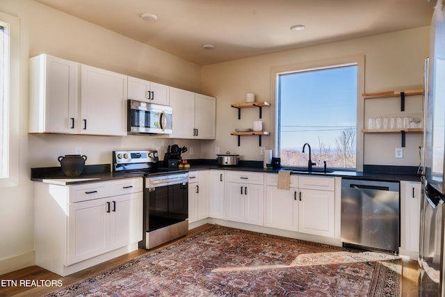 kitchen with stainless steel appliances, dark wood-type flooring, sink, and white cabinetry