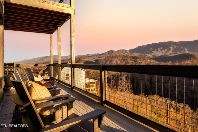 deck at dusk featuring a mountain view