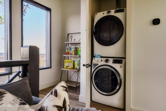 washroom with stacked washer / dryer and dark hardwood / wood-style flooring