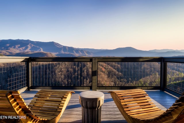 deck at dusk featuring a mountain view