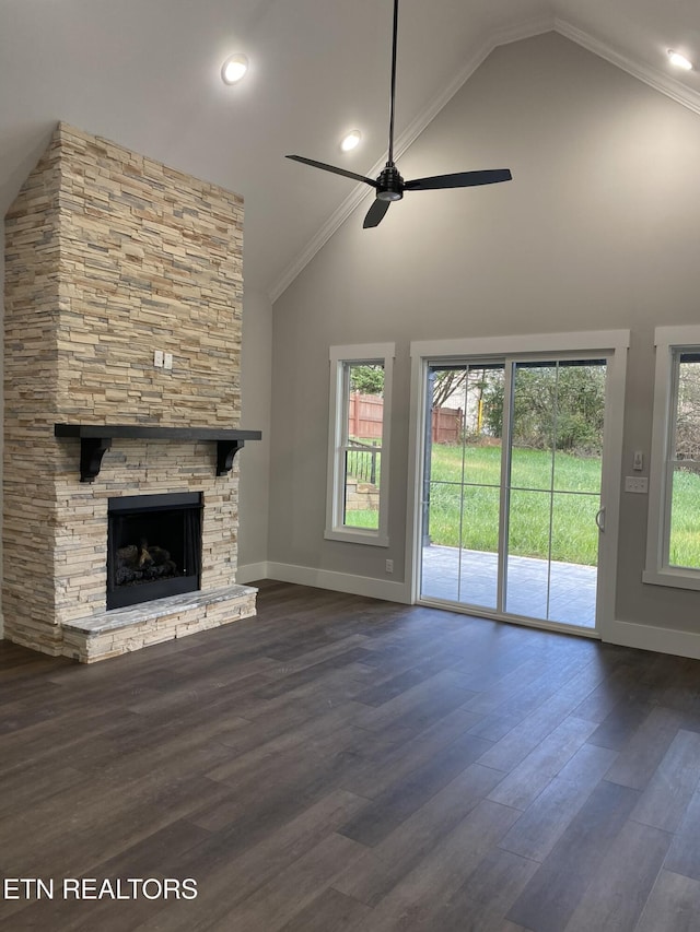 unfurnished living room with ceiling fan, a stone fireplace, high vaulted ceiling, dark hardwood / wood-style floors, and crown molding