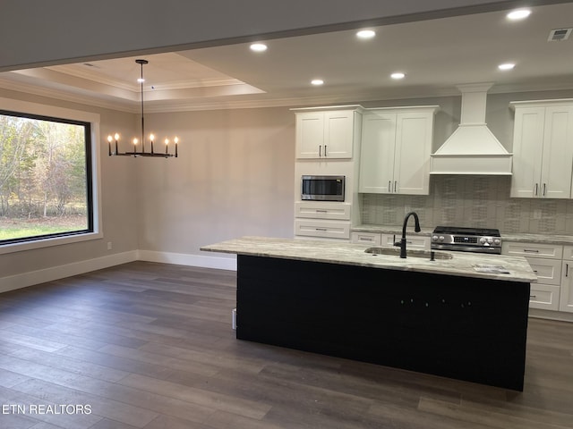 kitchen with custom range hood, stainless steel appliances, sink, pendant lighting, and white cabinetry