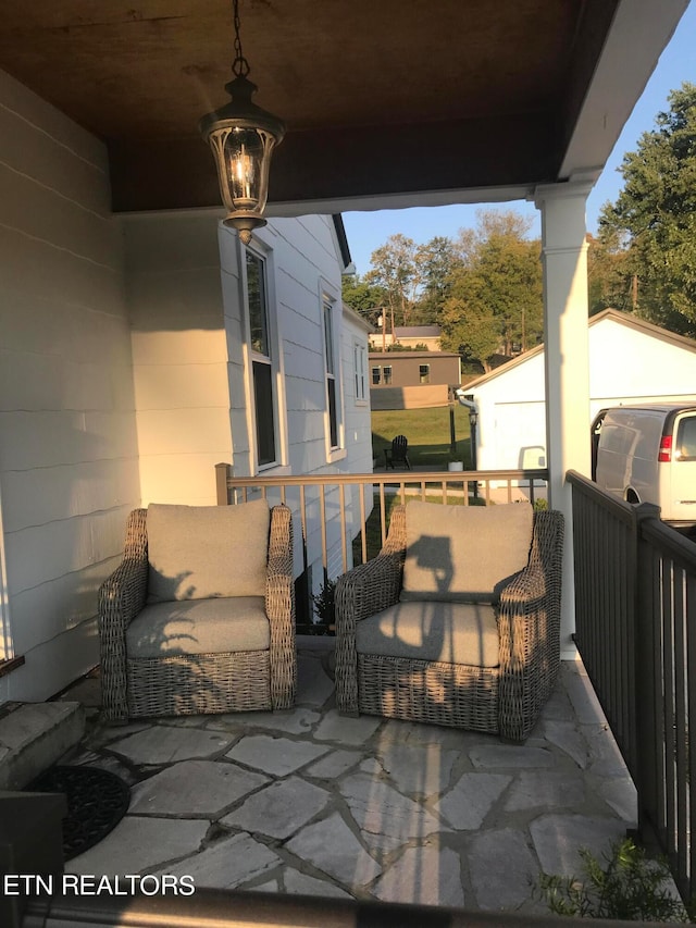 view of patio with an outbuilding and a garage