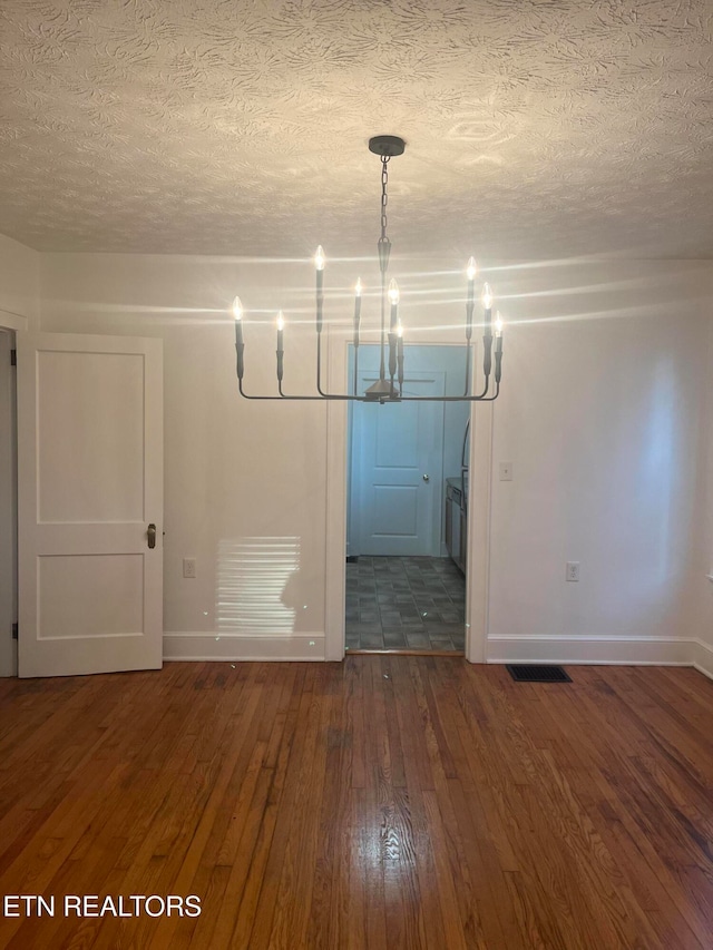 unfurnished room featuring a textured ceiling and dark wood-type flooring