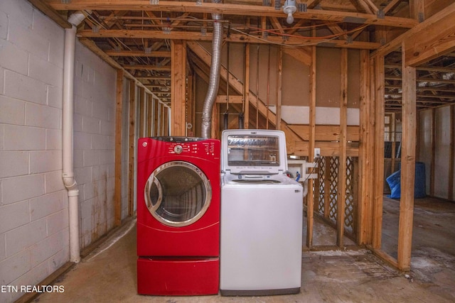 washroom with laundry area, independent washer and dryer, and concrete block wall