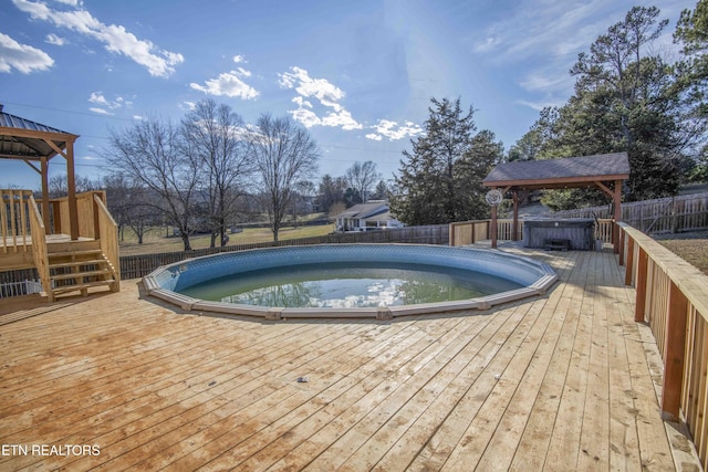 view of pool with a wooden deck, fence, a fenced in pool, and a gazebo