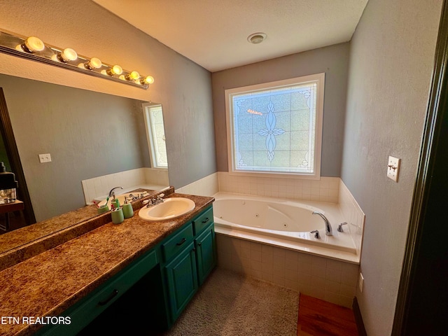 bathroom with vanity and tiled bath