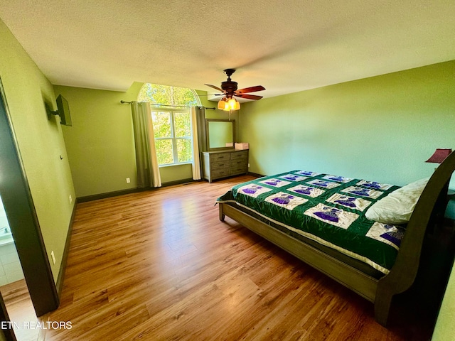 bedroom featuring a textured ceiling, hardwood / wood-style floors, and ceiling fan